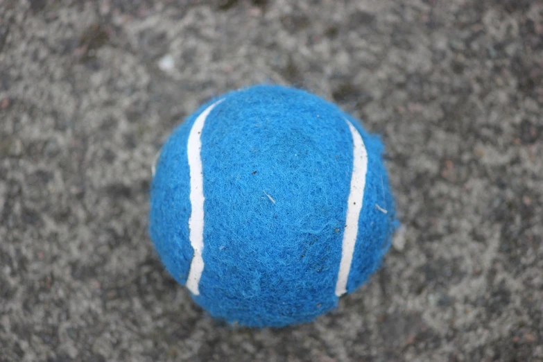 a close up of a tennis ball on the ground, by Helen Stevenson, bauhaus, needle felting, blues, taken with a pentax1000, but very good looking”