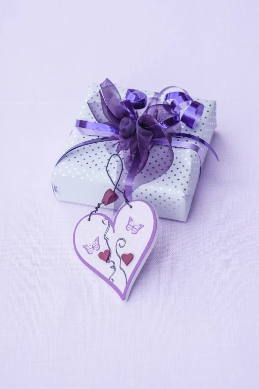 a white gift box with a purple ribbon and a heart shaped tag, a photo, miniature product photo, high details photo