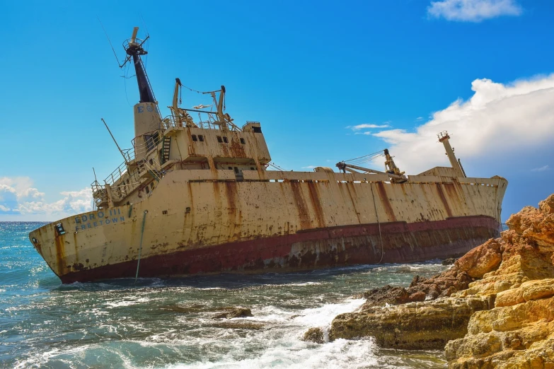 a rusted ship sitting on top of a rocky beach, a portrait, by derek zabrocki, pixabay, building crumbling, big graphic seiner ship, sinking, somalia