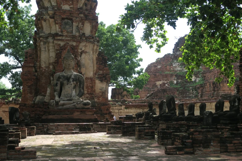 a group of statues sitting on top of a stone floor, flickr, thai architecture, ruined buildings, wikimedia commons, ancient catedral behind her