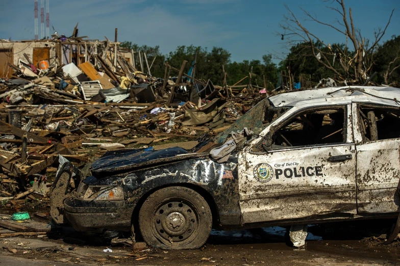 a police car parked in front of a pile of rubble, a photo, by Paul Davis, pixabay, photo of monstrous tornado, oklahoma, post apocalyptic police station, espn