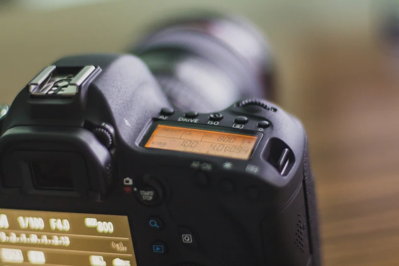 a digital camera sitting on top of a wooden table, by Romain brook, unsplash, close up dslr studio photograph, lcd screen, canon eos 6d, timelapse