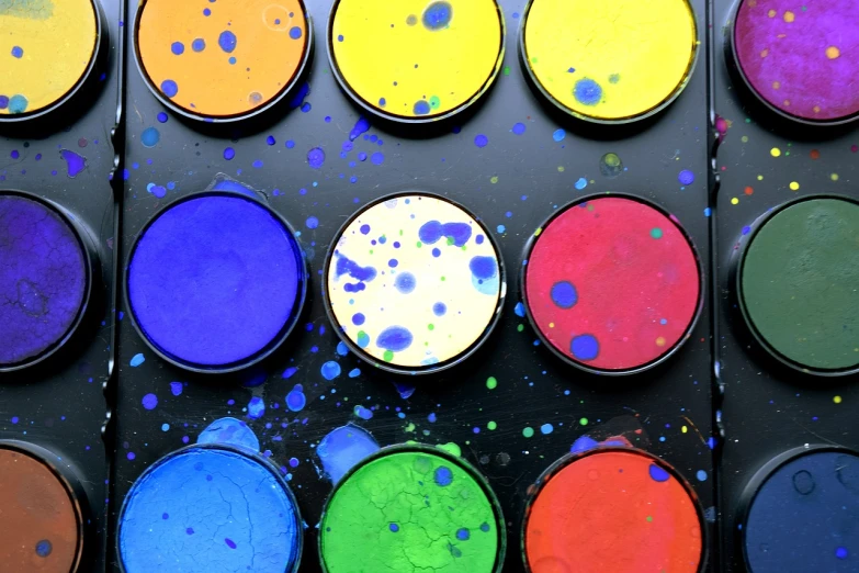 a close up of many different colors of paint, inspired by Sam Francis, pixabay, pointillism, drum pads, black paint, watercolor wash, 🎨🖌️