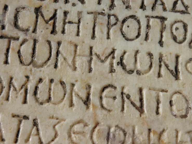 a close up of a stone with writing on it, by Romano Vio, letterism, codex, neon roman, image, school class