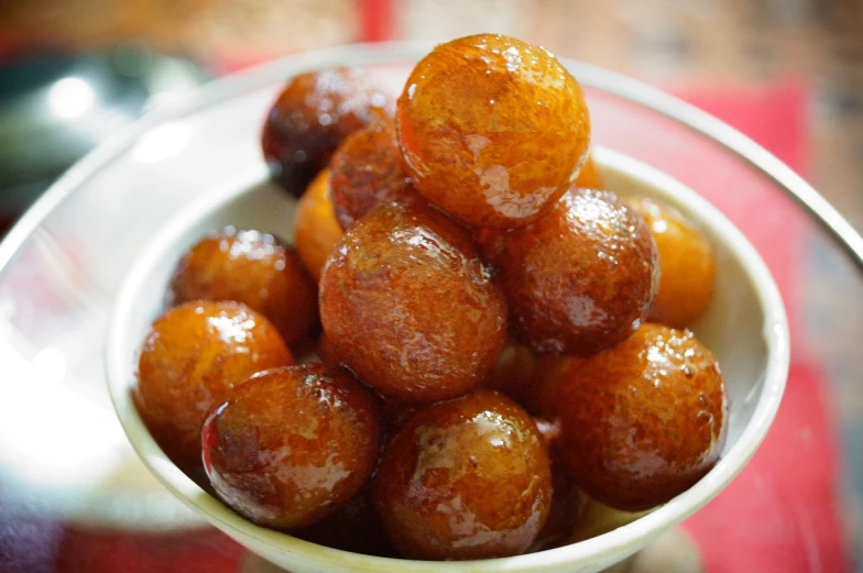 a close up of a bowl of food on a table, pixabay, dau-al-set, made of glazed, ball, syrup, puffy