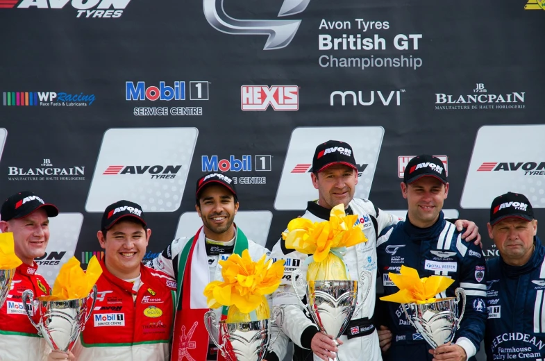 a group of men standing next to each other on a podium, a photo, by Kev Walker, flickr, motor sport photography, josh grover, british, very very happy!