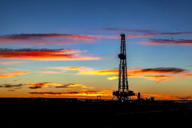 a drilling rig is silhouetted against a sunset sky, a stock photo, pixabay, uploaded, colorado, at dusk!, looking into the horizon