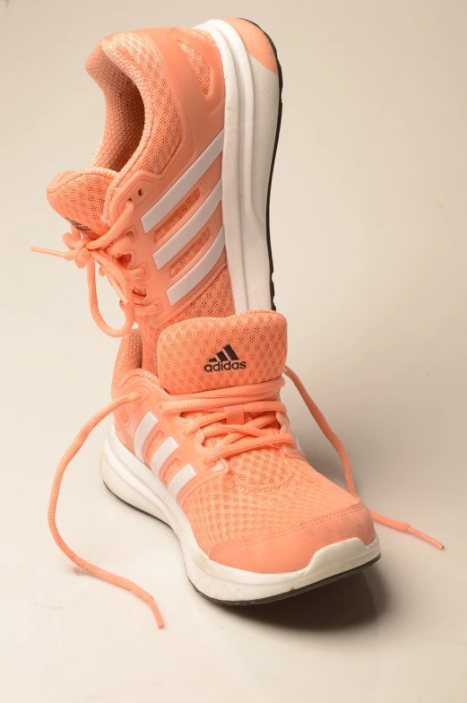 a close up of a pair of shoes on a white surface, pixabay, in shades of peach, adidas, athletic muscle tone, very hyper realistic