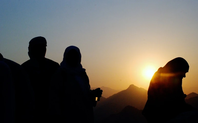 a group of people standing next to each other, a picture, by Matt Stewart, flickr, hurufiyya, sun rises between two mountains, islam, wining, mekka