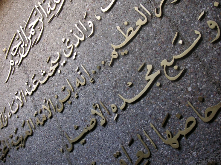 a close up of arabic writing on a wall, an engraving, flickr, monument, installation, al jazeera, kawaai