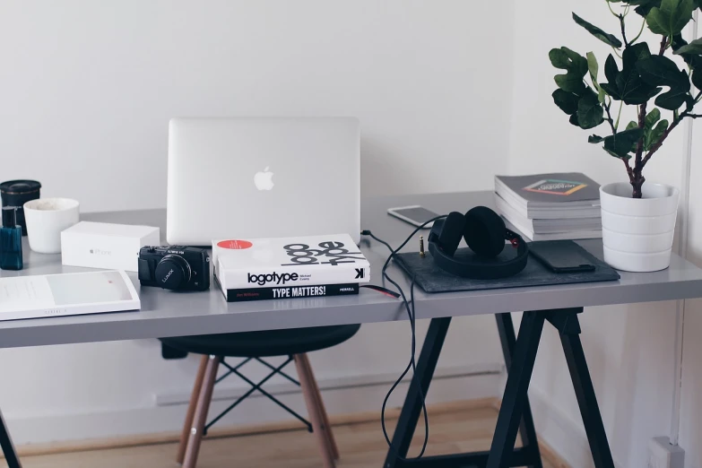 a laptop computer sitting on top of a wooden desk, unsplash, minimalism, books on side table, headphone stand, at behance, office clothes