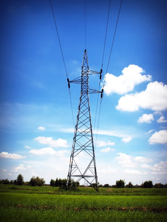 an electricity tower in the middle of a field, a picture, flickr, [ [ hyperrealistic ] ], blue skies, éclairage volumétrique, really long