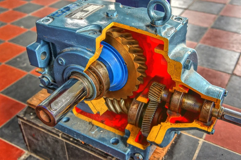 a close up of a machine on a tiled floor, by Bernardino Mei, pexels, exposed inner gears, red blue and gold color scheme, highly detailed product photo, stock photo