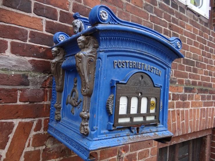 a blue mail box sitting on the side of a brick building, by Christen Købke, pixabay, intricate and ornate, postman pat, very very very highly detailed, lantern