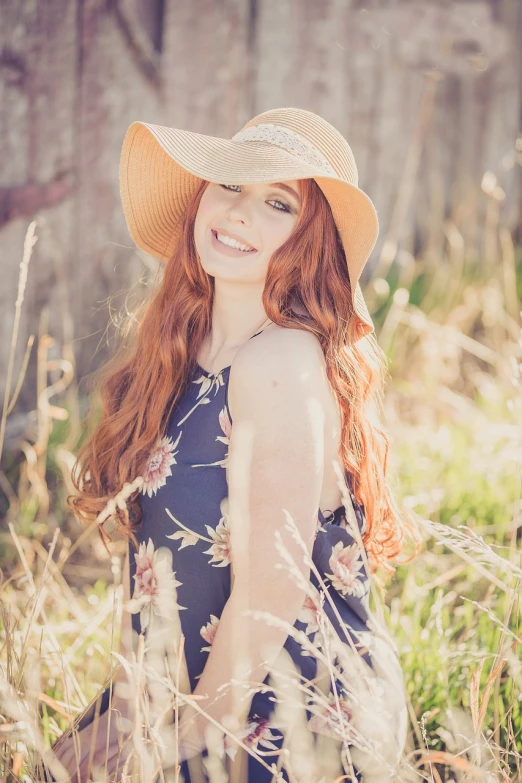 a girl is sitting in the middle of tall grass