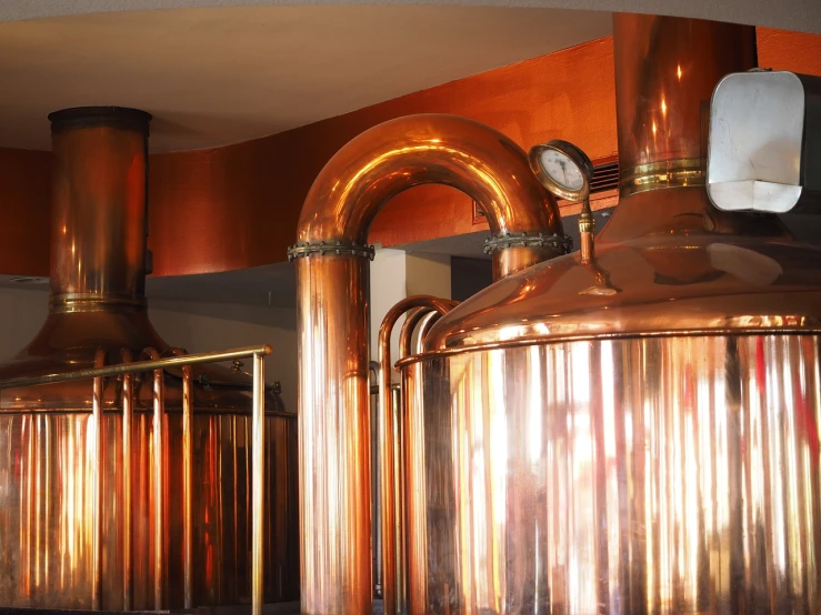 a couple of copper tanks sitting next to each other, pixabay, beer, golden pillars, indoor, screencapture