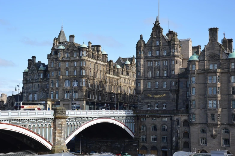 a large building with a bridge in front of it, by John Murdoch, pixabay, art nouveau, scottish style, the neat and dense buildings, zoomed out shot, hotel