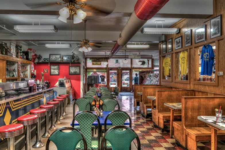 a restaurant with red walls and green chairs and tables