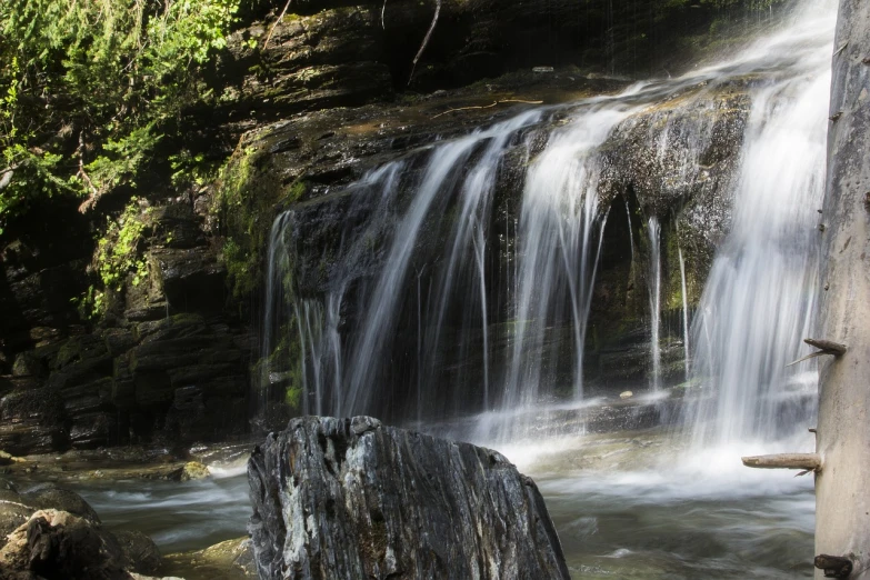 a waterfall has water cascading all around it