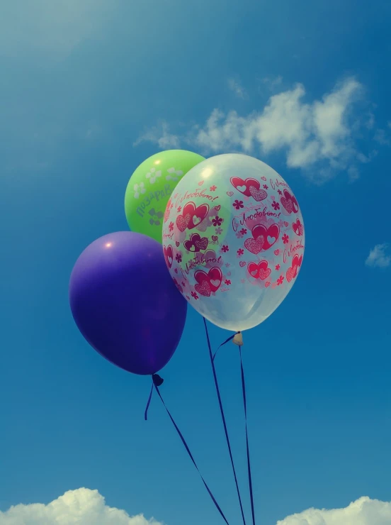 a close - up of several balloons against a blue sky