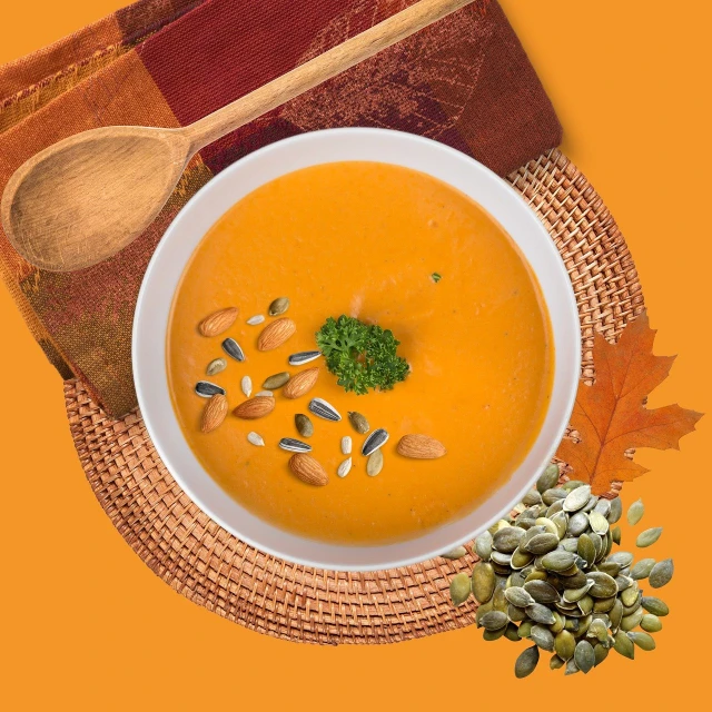 a white bowl with some pumpkin colored soup in it