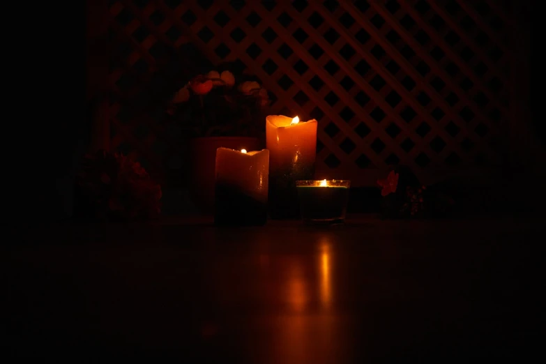 two lit candles on the floor in a dark room