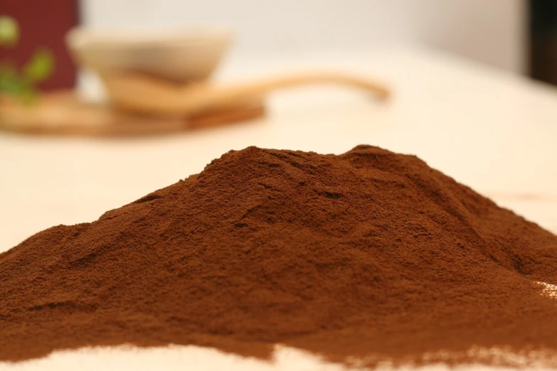 powdered brown dirt next to spoon on counter