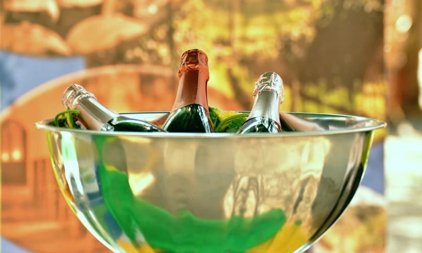 three champagne bottles in an aluminum bowl are sitting next to each other