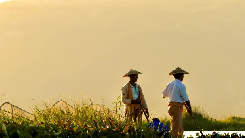 two men dressed in traditional mexican clothing walking in the grass