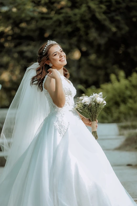 a smiling woman in a wedding dress holds her bouquet