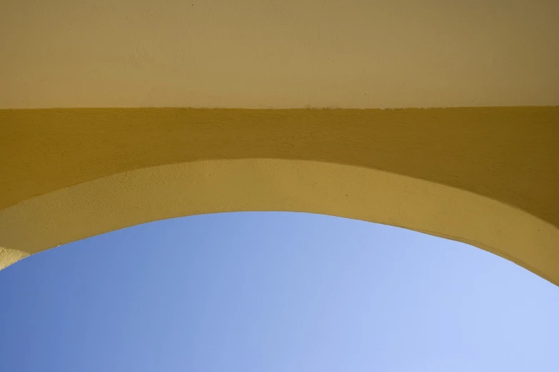 a clock hanging off the side of a yellow building