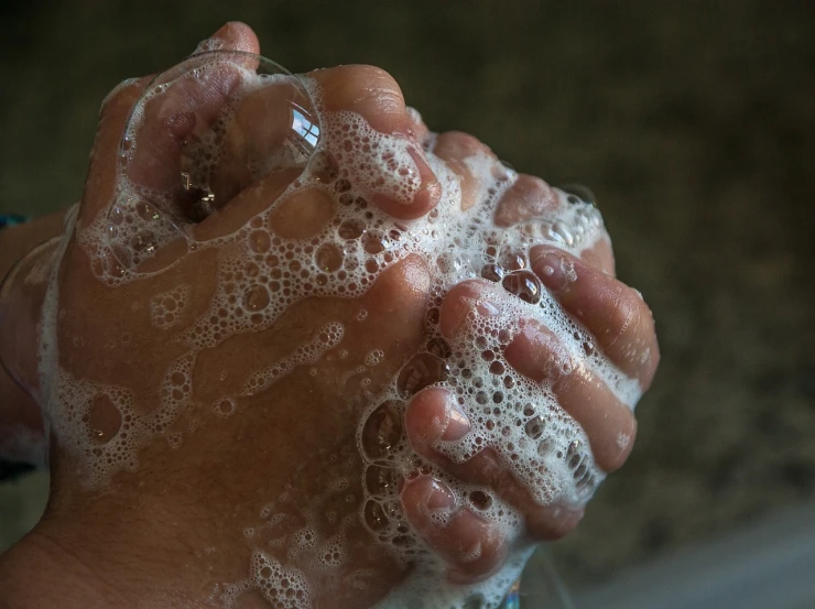 a person's hands are covered in foamy water