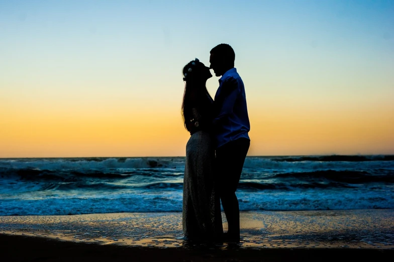 a silhouette po of a couple at the beach