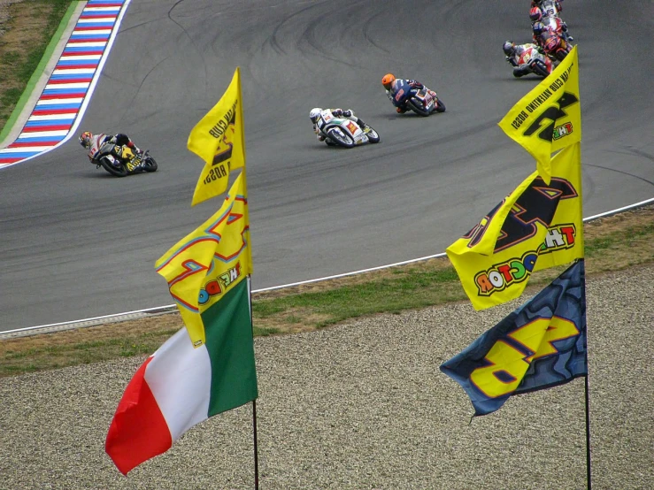 motorcyclists race on a racing track during the day