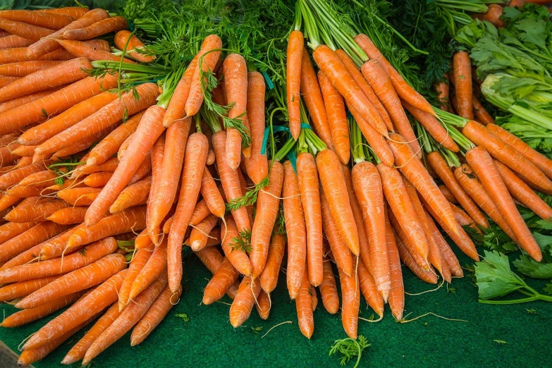 carrots and herbs displayed in large bowls on display