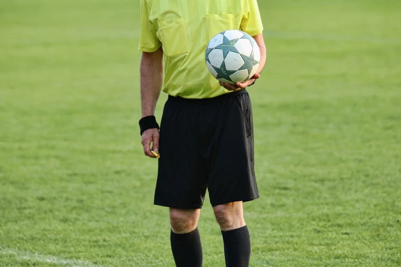 the man is standing in the field with a ball