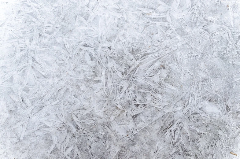 white frost on a window with snow flakes