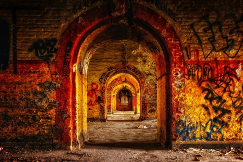 a painting with graffiti and brick arches at an old abandoned building