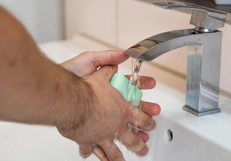 a person washing their hands in the sink