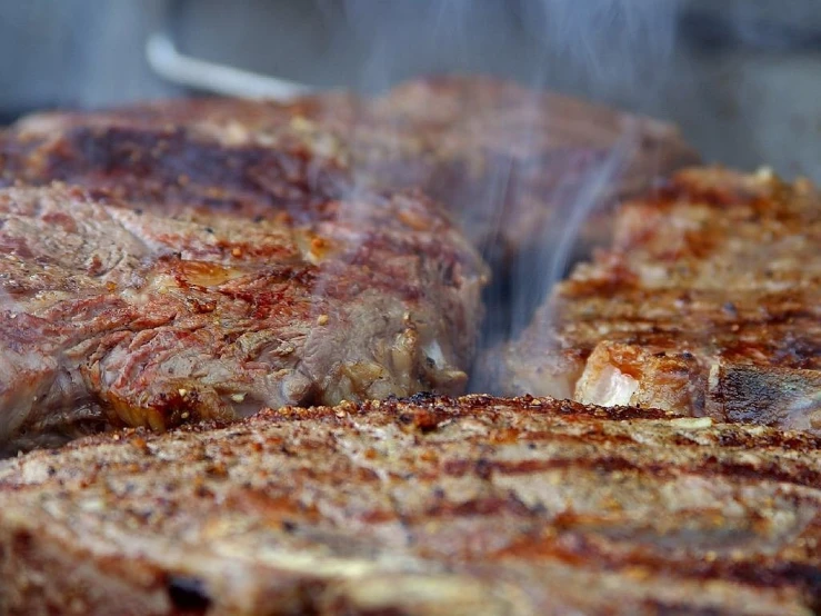 steaks cooking on the grill in the sun