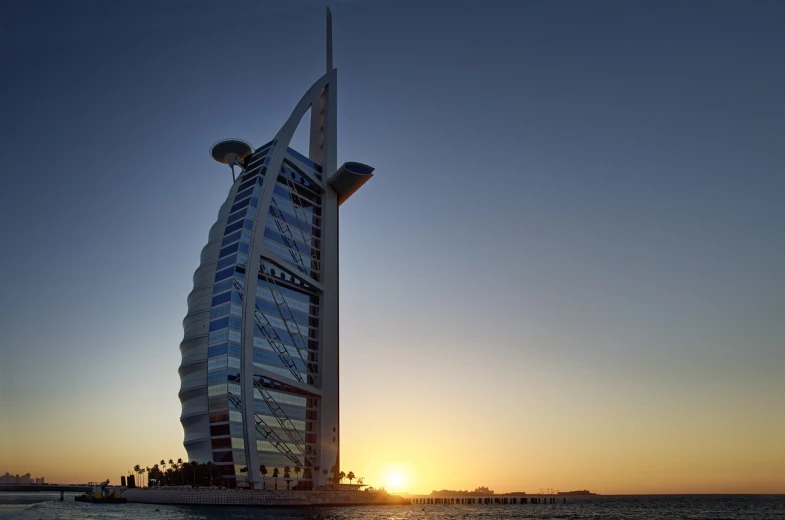 the burj tower on the water during sunset