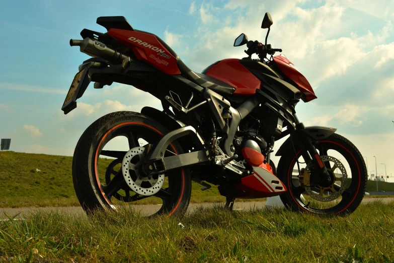 a red motorcycle is parked in the grass