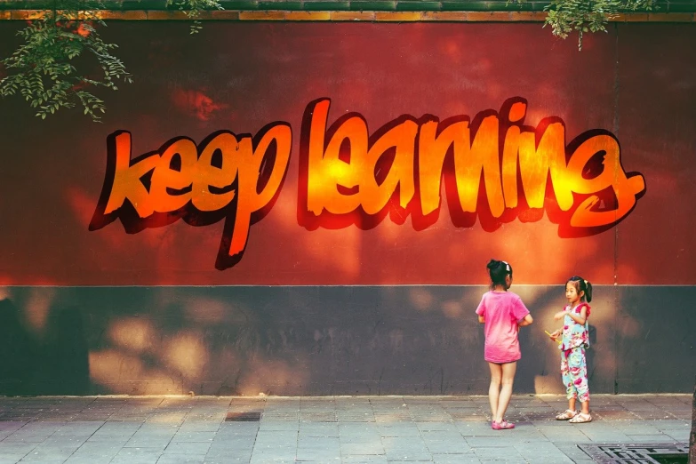 two little girls are looking at soing under the sign