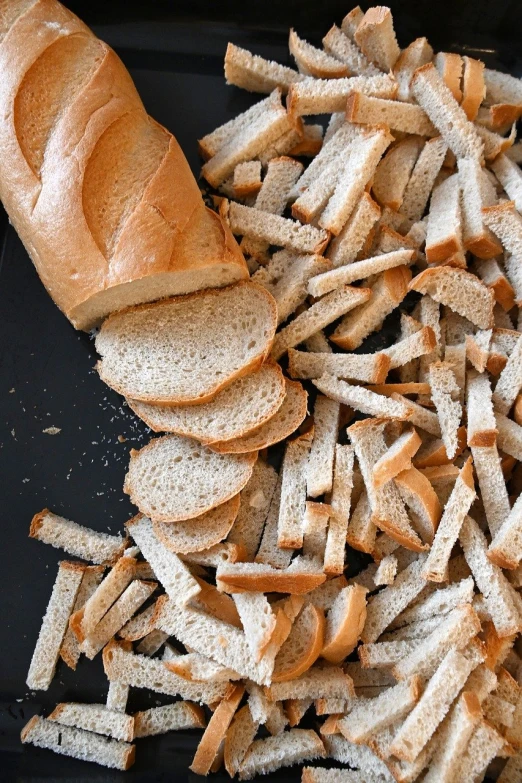 toasted bread and sliced up bread sticks sitting in front of the sandwich on a tray
