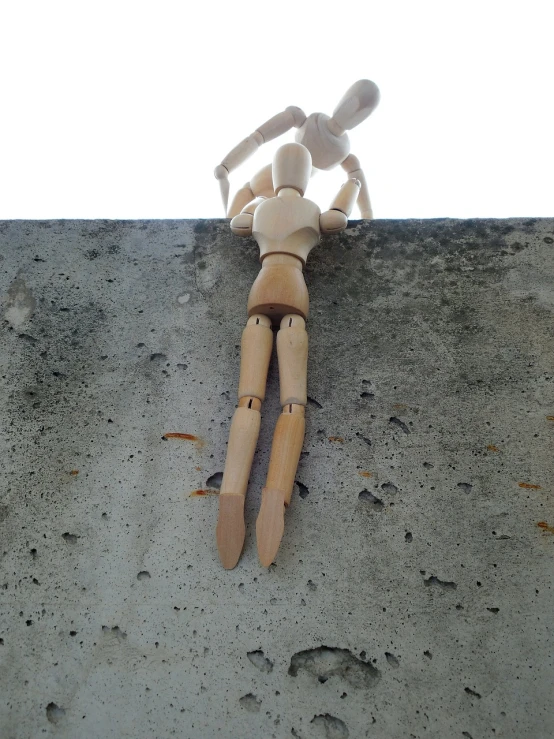 a wooden dummy laying on the concrete outside