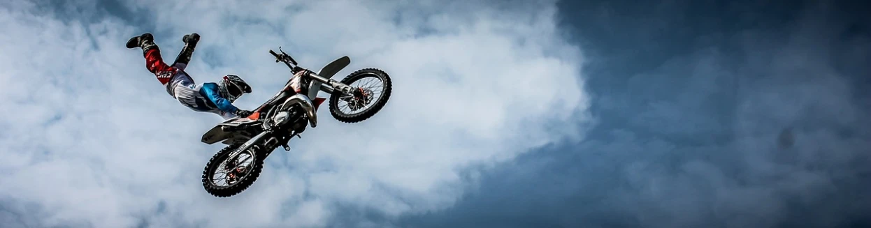 a man is doing a trick on a motorcycle in the air