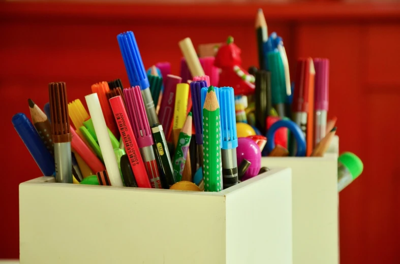 pencils are lined up in small white pots