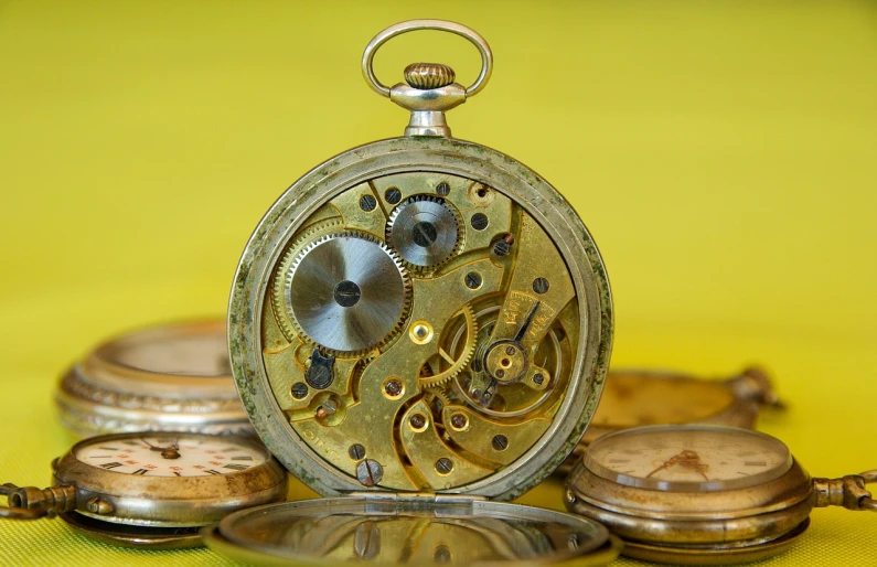 an antique pocket watch sitting next to its respective key