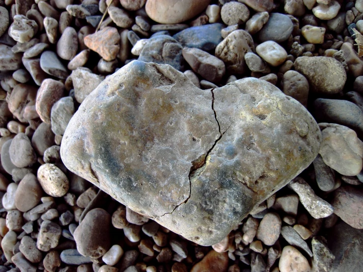 a heart shaped rock that is on some gravel