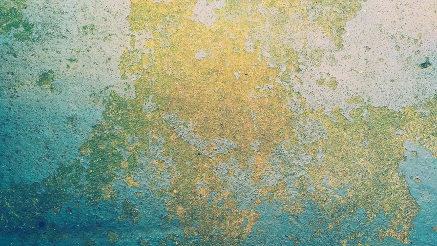 an old, peeling wall has yellow and blue paint